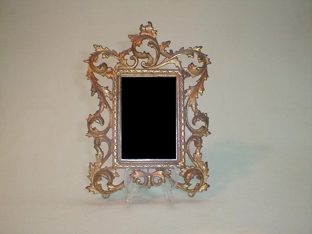 Appraisal: A gilt cast metal wall mirror with scrolling frame x