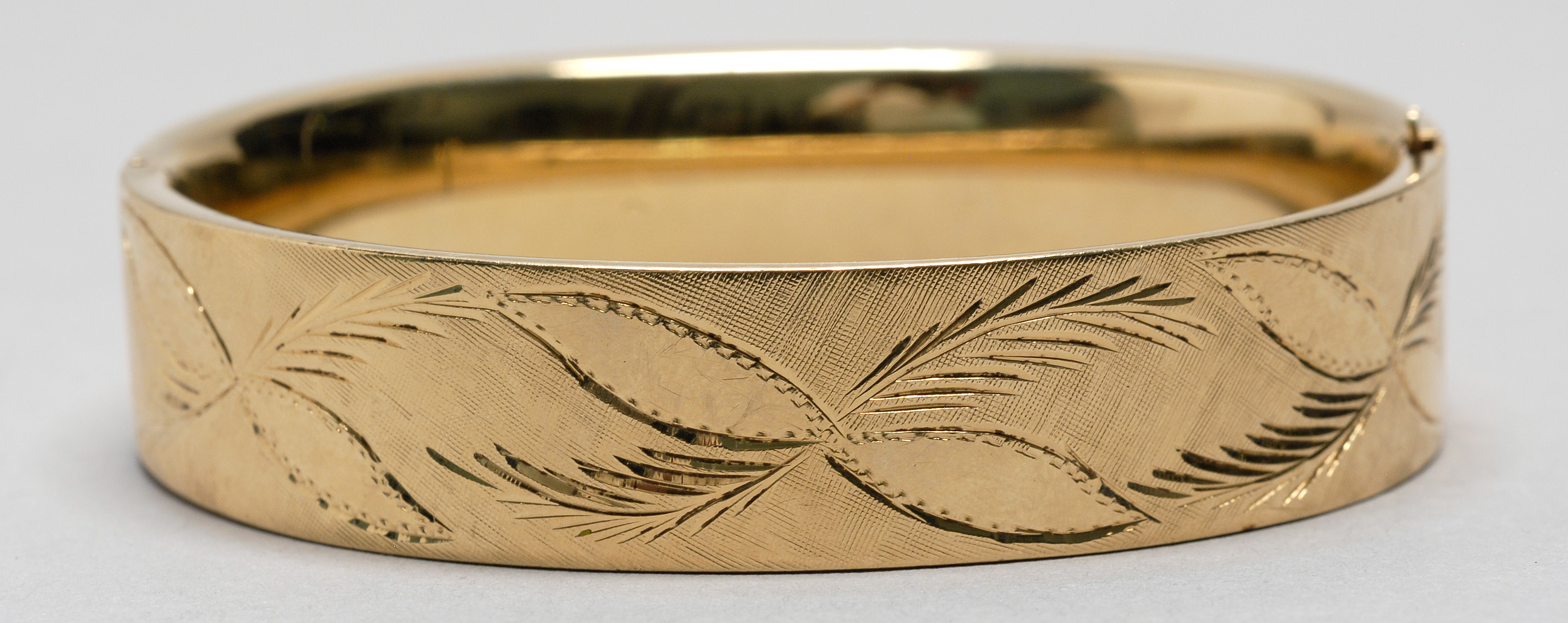 Appraisal: KT YELLOW GOLD BANGLE BRACELET Hinged with engraved foliate design