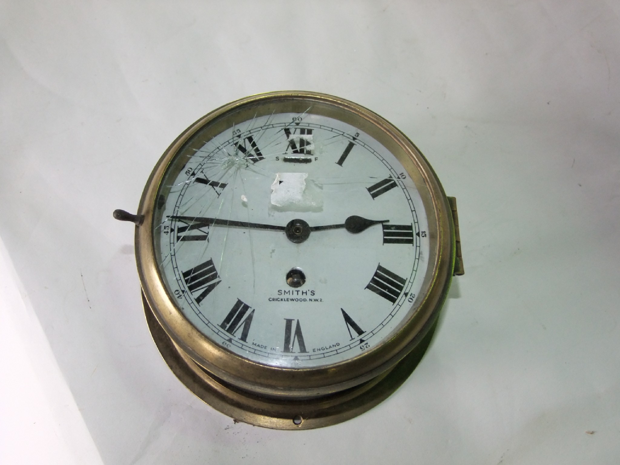 Appraisal: A Smiths marine bulkhead clock with part brass case enamel