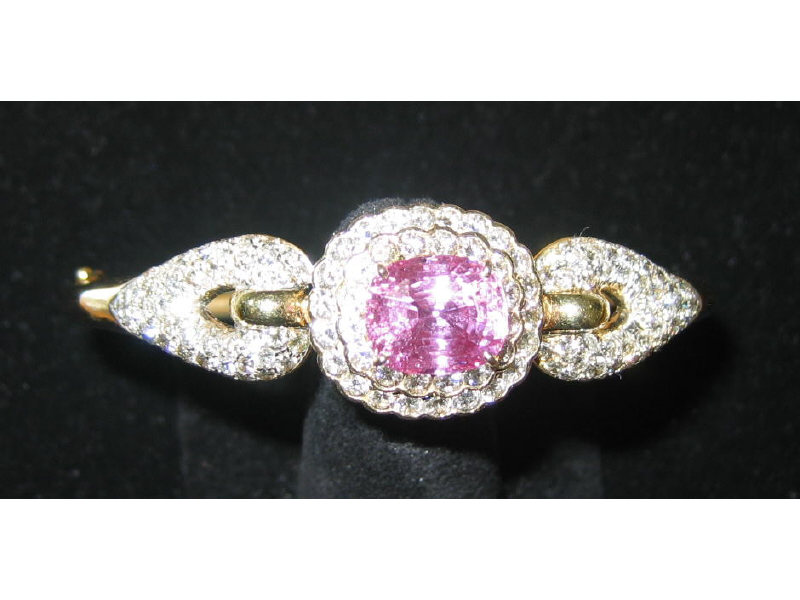 Appraisal: PINK SAPPHIRE AND DIAMOND BANGLE BRACELET With cushion cut faceted