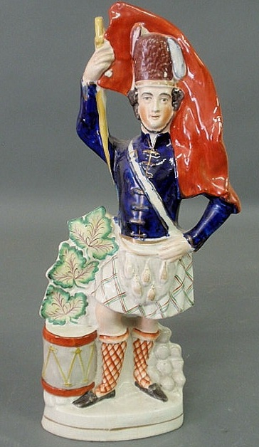 Appraisal: Staffordshire figure of a Scottish soldier with a raised red