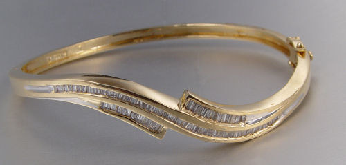 Appraisal: K DIAMOND BANGLE BRACELET K yellow gold wave shaped hinged