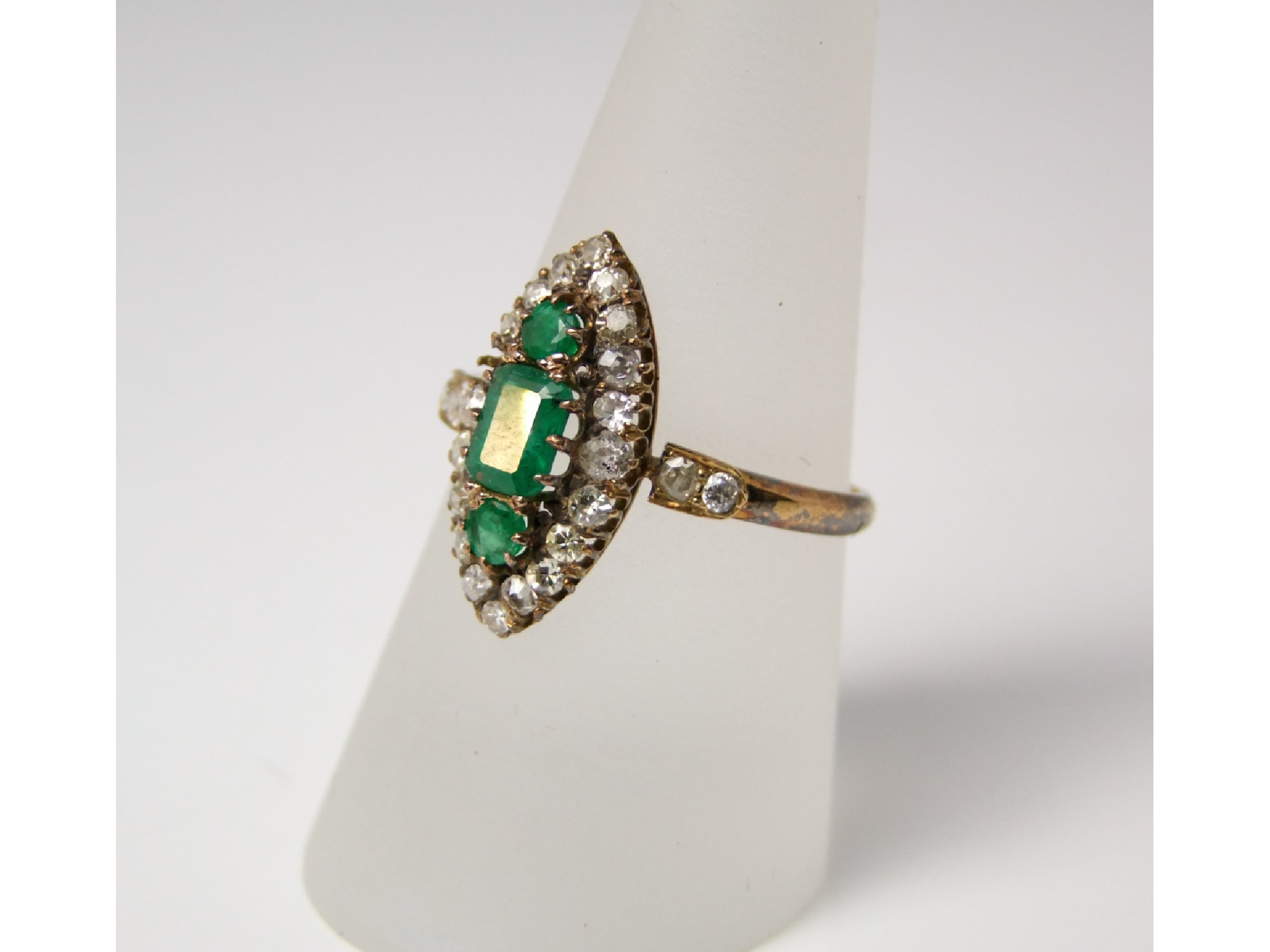 Appraisal: A marquise shaped emerald and diamond cluster ring set with