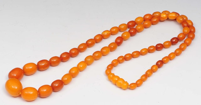 Appraisal: A graduated amber bead necklace cm long