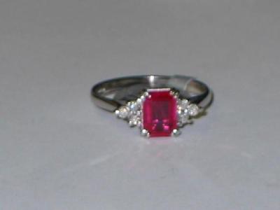 Appraisal: A RUBY AND DIAMOND RING the emerald cut ruby claw