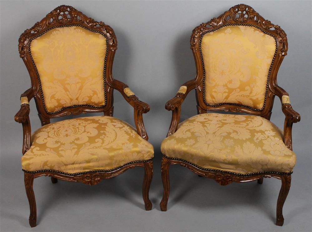 Appraisal: PAIR OF ROCOCO REVIVAL CHERRYWOOD UPHOLSTERED OPEN ARMCHAIRS having a