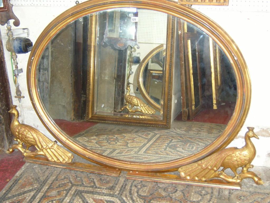 Appraisal: A Regency style overmantle mirror of oval form with peacock