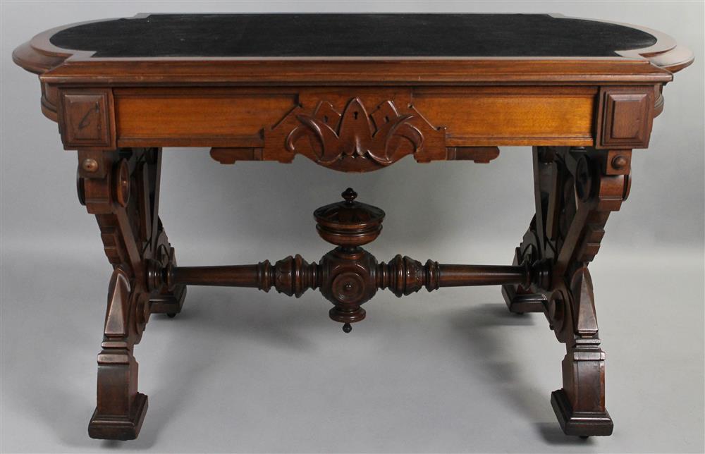 Appraisal: AESTHETIC MOVEMENT CARVED WALNUT ASTRAGAL FORM LIBRARY TABLE having a