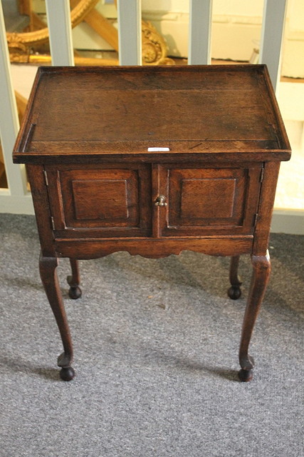 Appraisal: AN ANTIQUE OAK TRAY TOP BEDSIDE TABLE with cupboard doors