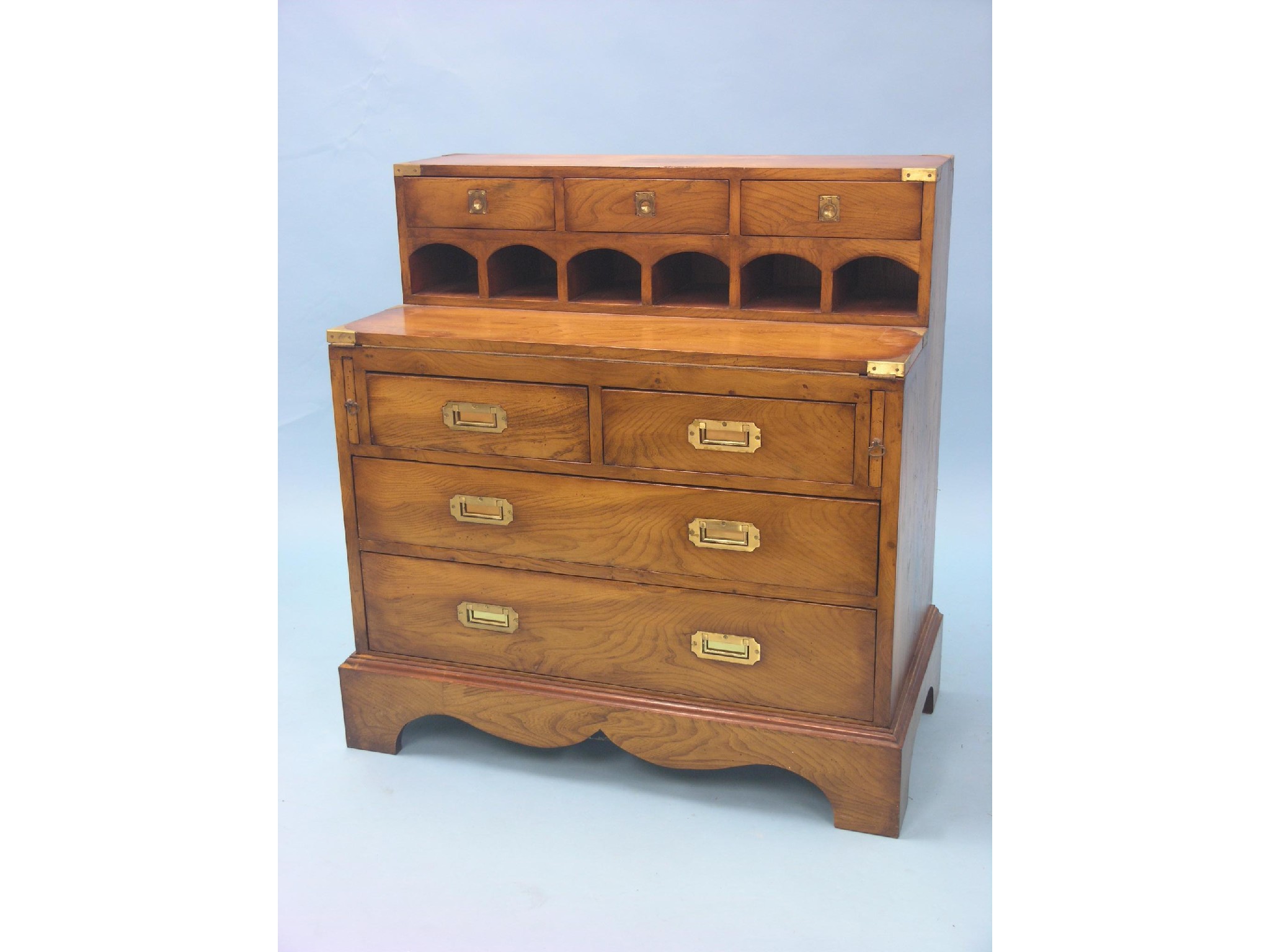 Appraisal: A reproduction light elm writing cabinet three raised drawers above