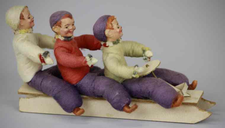 Appraisal: THREE HEUBACH BOYS ON A SLED ORNAMENT Germany features three