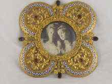 Appraisal: A pendant quatrefoil gilt and enamelled metal photo frame set