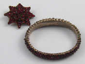 Appraisal: A white metal tests silver Bohemian garnet bangle internal width