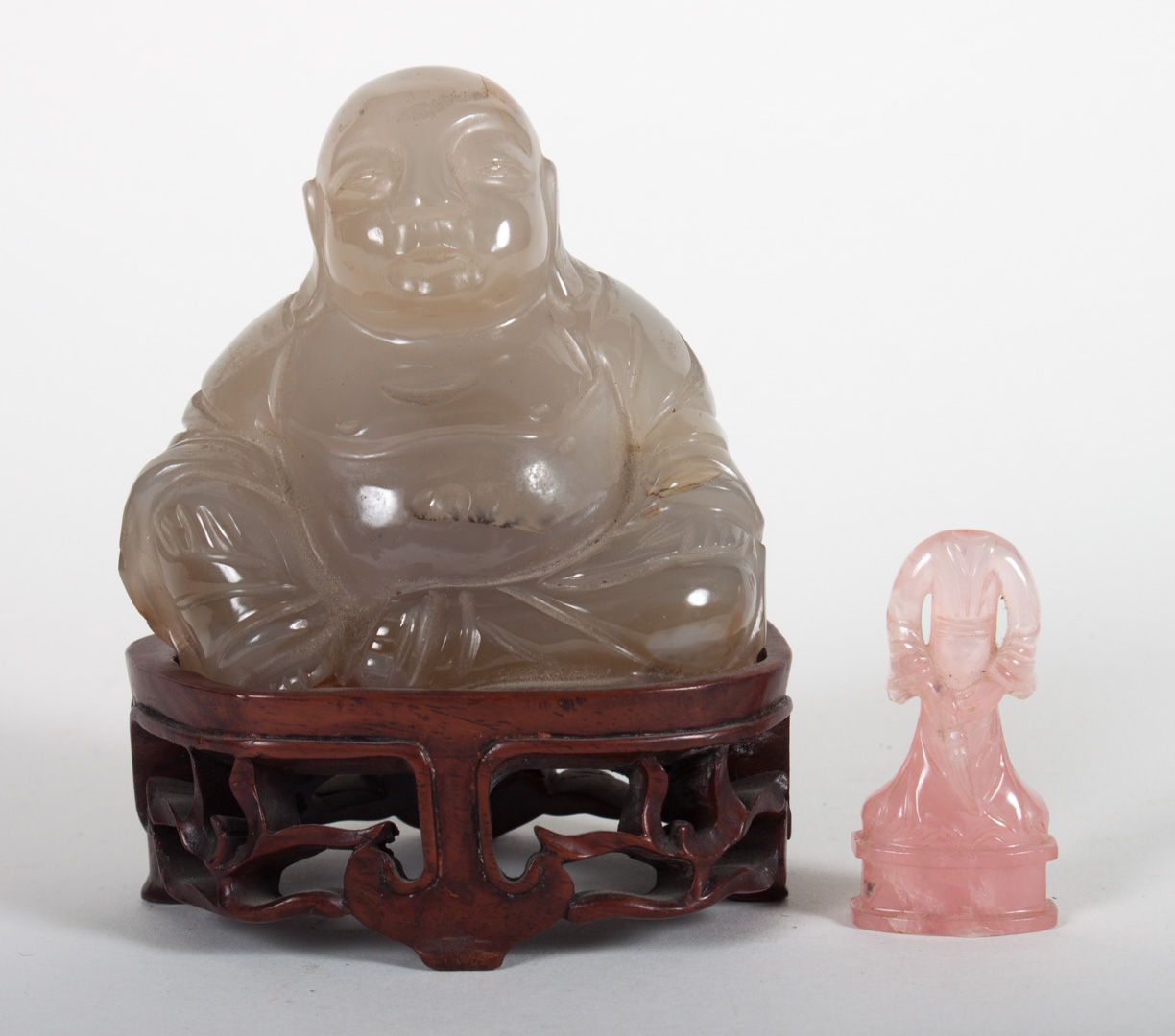 Appraisal: Two Chinese carved hardstone figures seated Buddha on wood stand