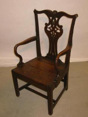 Appraisal: A GEORGE III ELM ELBOW CHAIR the shaped top rail