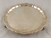 Appraisal: A sterling silver waiter with shaped rim on three scroll