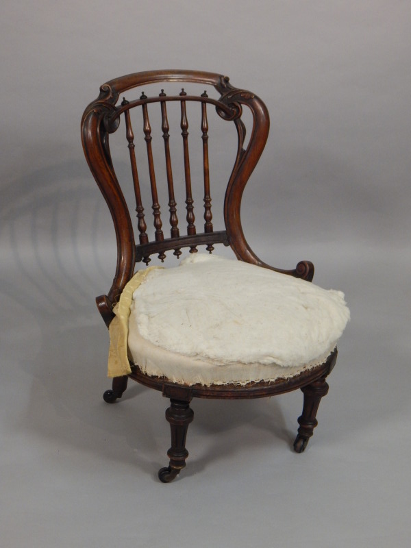 Appraisal: A Victorian mahogany nursing chair with a spindle turned back