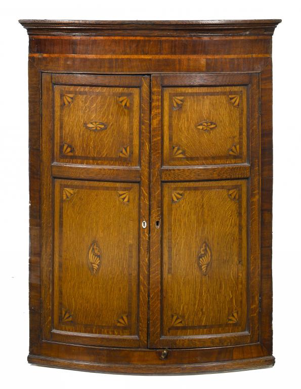 Appraisal: A GEORGE III OAK BOW FRONTED CORNER CUPBOARD crossbanded in