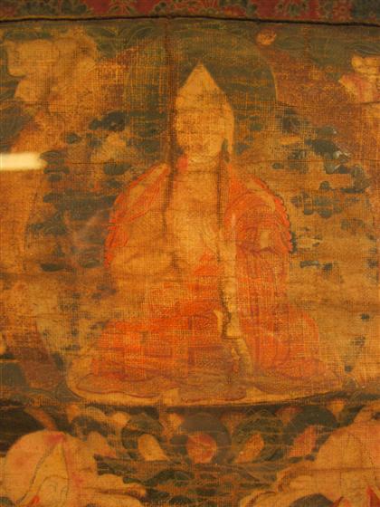 Appraisal: Tibetan needlework thangkaDepicting a seated Buddhist deity surrounded by lotus