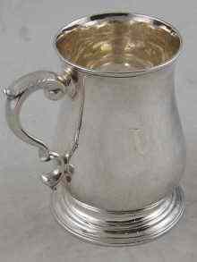 Appraisal: A Georgian silver baluster mug with leaf capped scroll handle