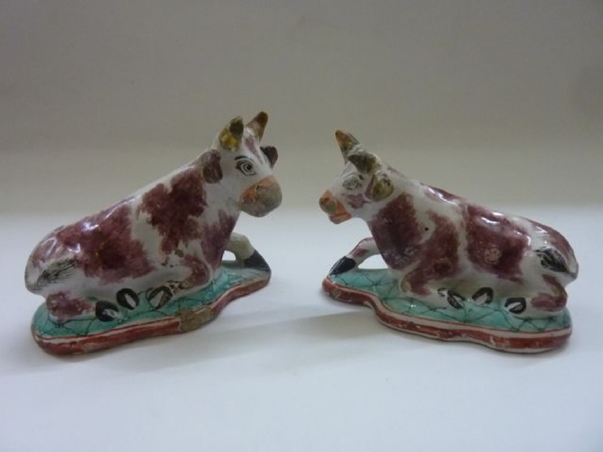 Appraisal: A pair of th century Delft recumbent cows with painted