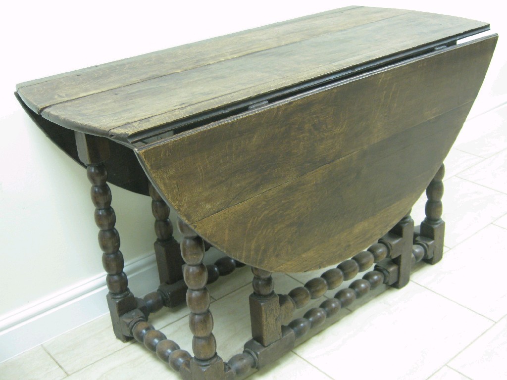 Appraisal: A jacobean oak gate-leg Table with oval top on bobbin