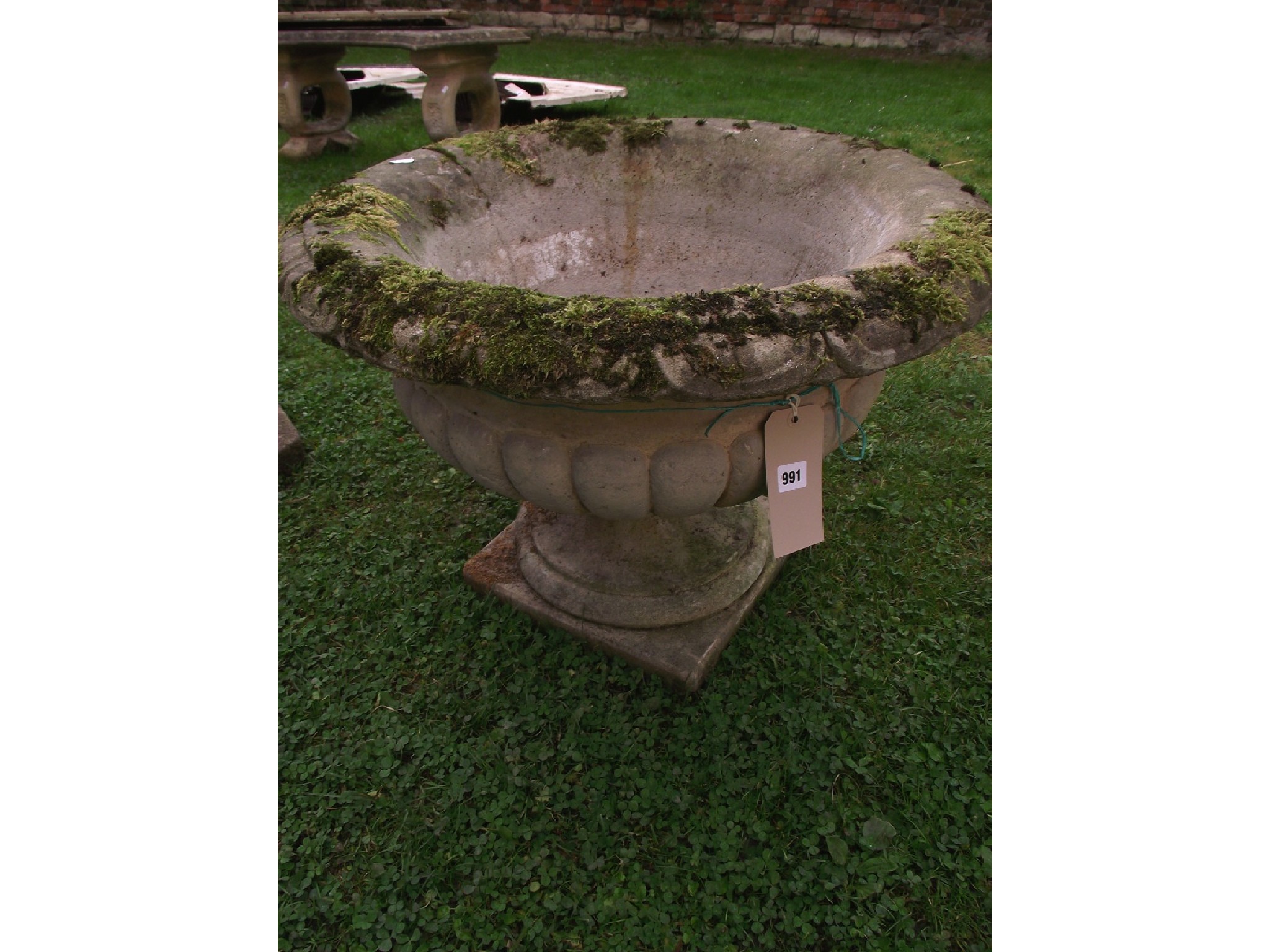 Appraisal: A weathered cast composition stone garden urn the squat circular