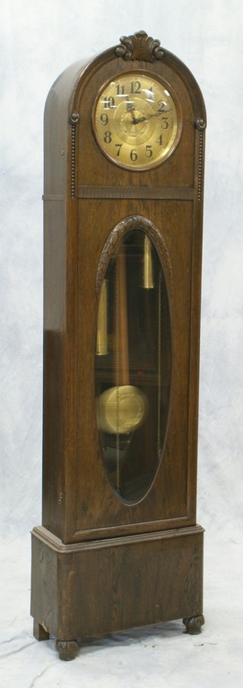 Appraisal: German oak hall clock round hammered brass dial weight pull