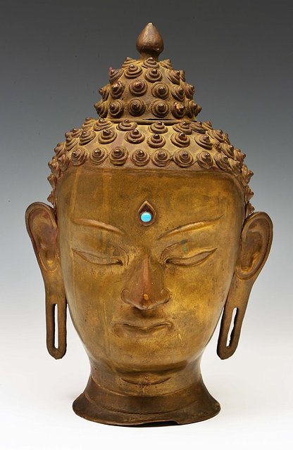 Appraisal: The McKelney CollectionA TIBETAN BRONZE BUDDHA HEAD with inset turquoise