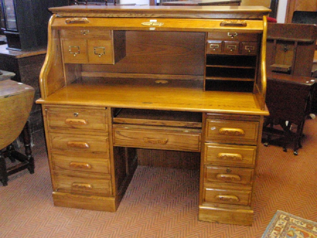 Appraisal: A reproduction oak roll top desk with S shape tambour