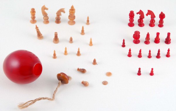 Appraisal: Miniature chess set of carved ivory Sixteen red pieces and