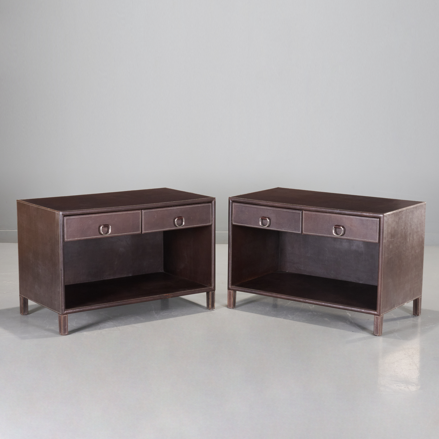 Appraisal: PAIR LEATHER-WRAPPED BEDSIDE TABLES PETER MARINO th c USA stitched