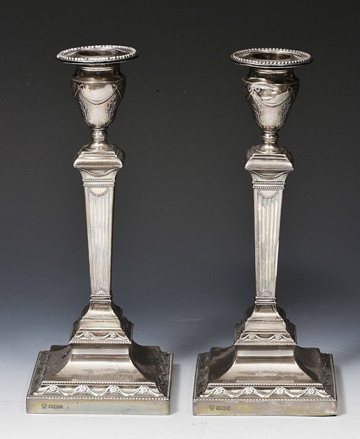 Appraisal: A PAIR OF CLASSICAL STYLE SILVER CANDLESTICKS with tapering column