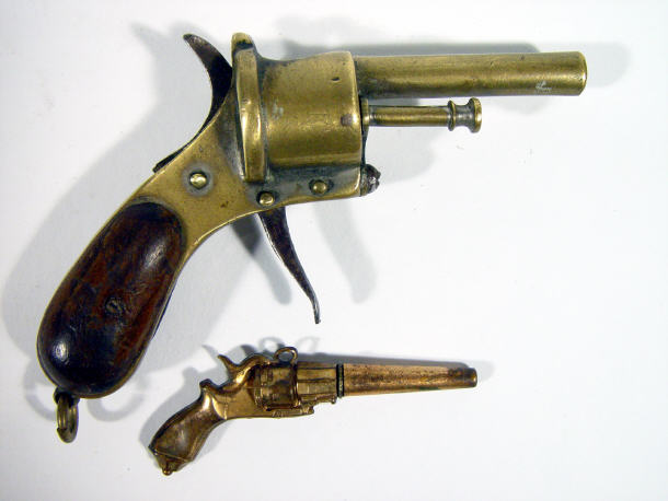 Appraisal: Miniature brass percussion pistol and a gilt metal pistol pendant