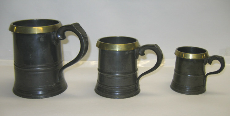 Appraisal: THREE ENGLISH PEWTER MEASURING TANKARDS Each handled tapered with brass