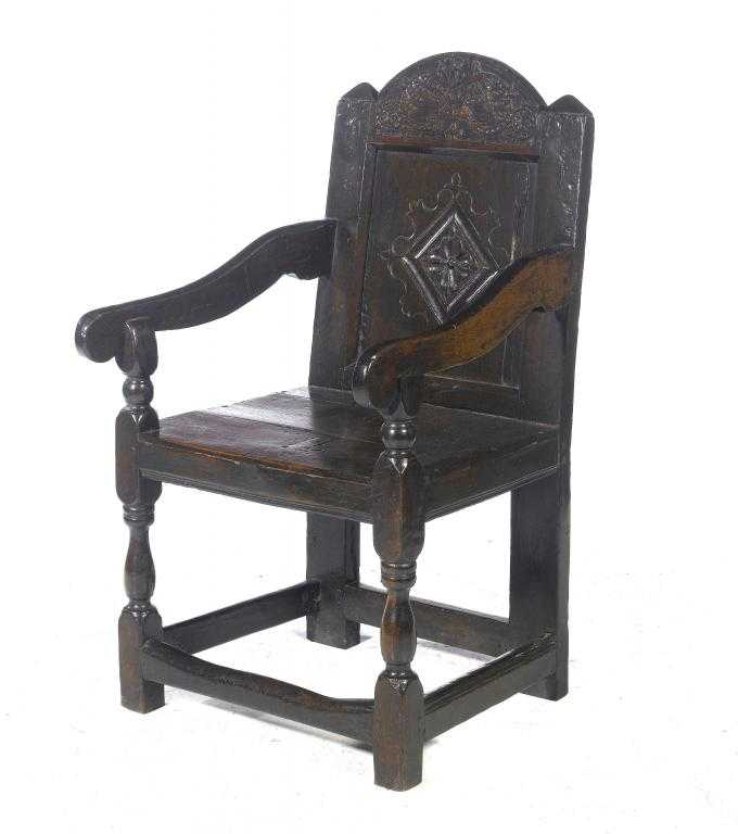 Appraisal: AN ENGLISH PANEL-BACK ARMCHAIR the arched top rail carved with