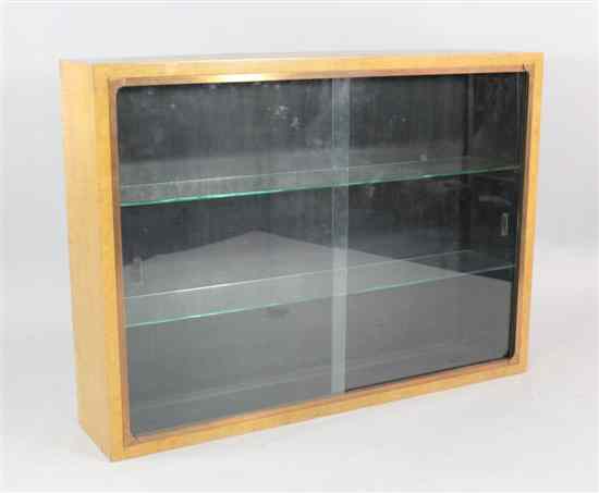 Appraisal: An Art Deco maple dwarf bookcase with copper framed sliding