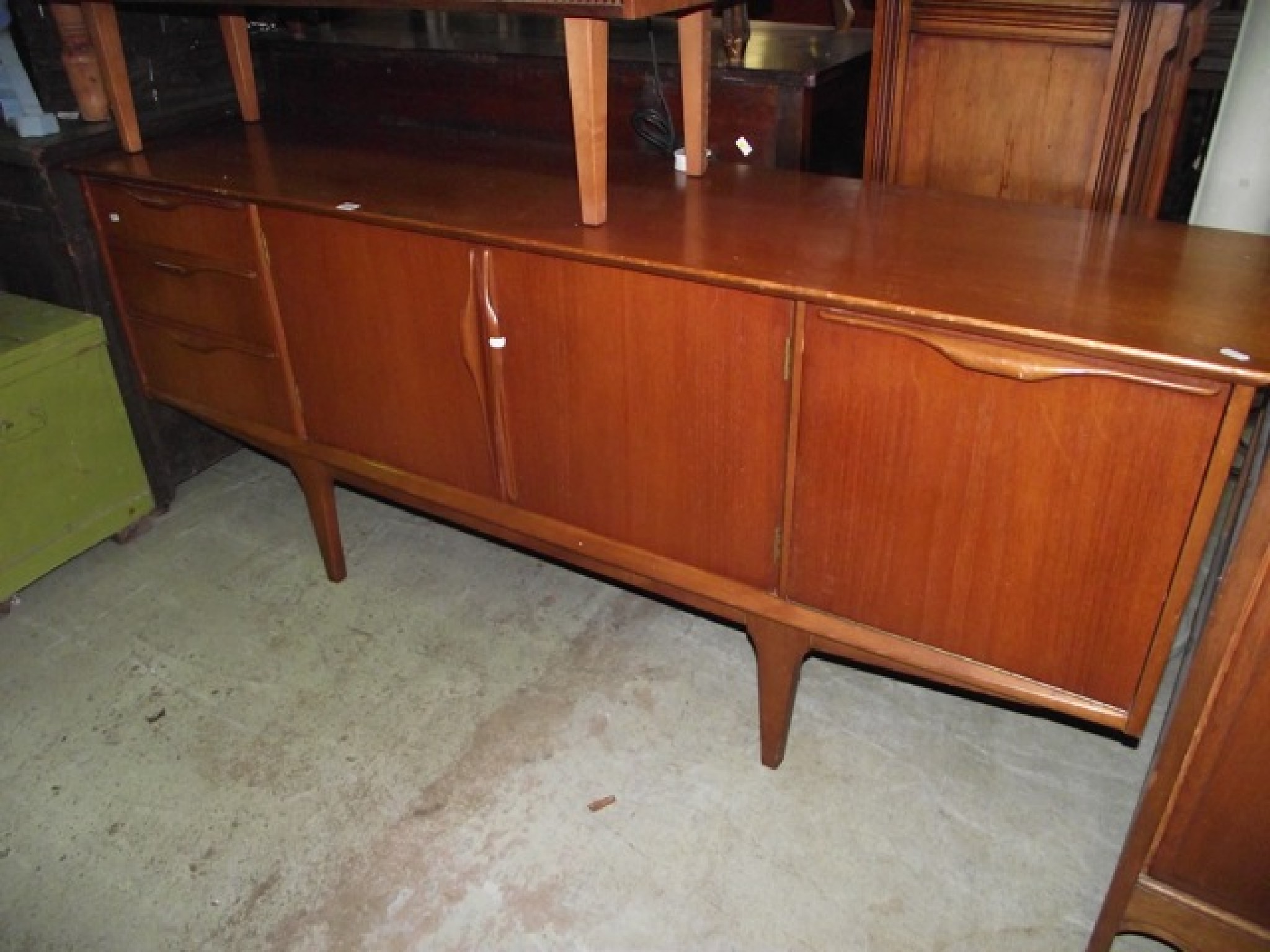 Appraisal: A mid- th century low and long teak sideboard enclosed