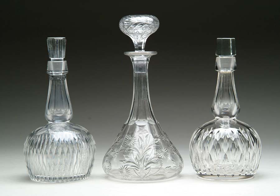 Appraisal: THREE CUT GLASS DECANTERS Cut glass decanter in a fluted