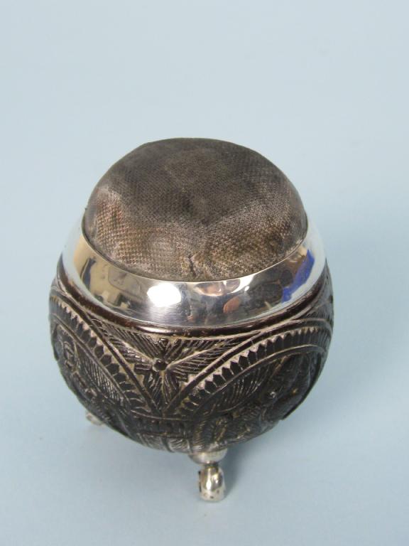 Appraisal: A silver mounted coconut Pin Cushion carved with figures