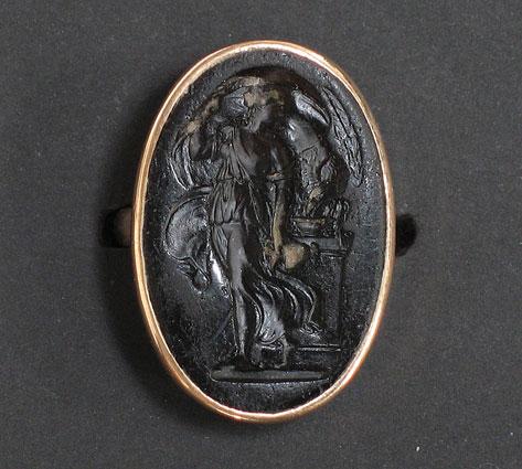 Appraisal: A GENTLEMAN'S SEAL RING the oval carved amber intaglio depicting