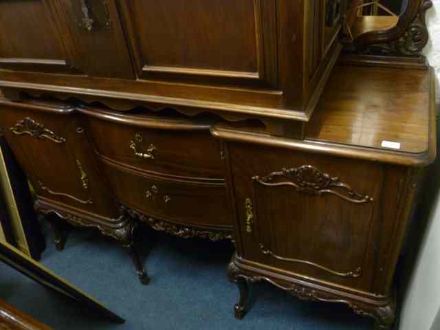 Appraisal: A WALNUT SIDEBOARD fitted with stylised mirror back with carved