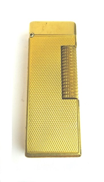 Appraisal: A gilt metal cased Dunhill rectangular gas lighter with engine