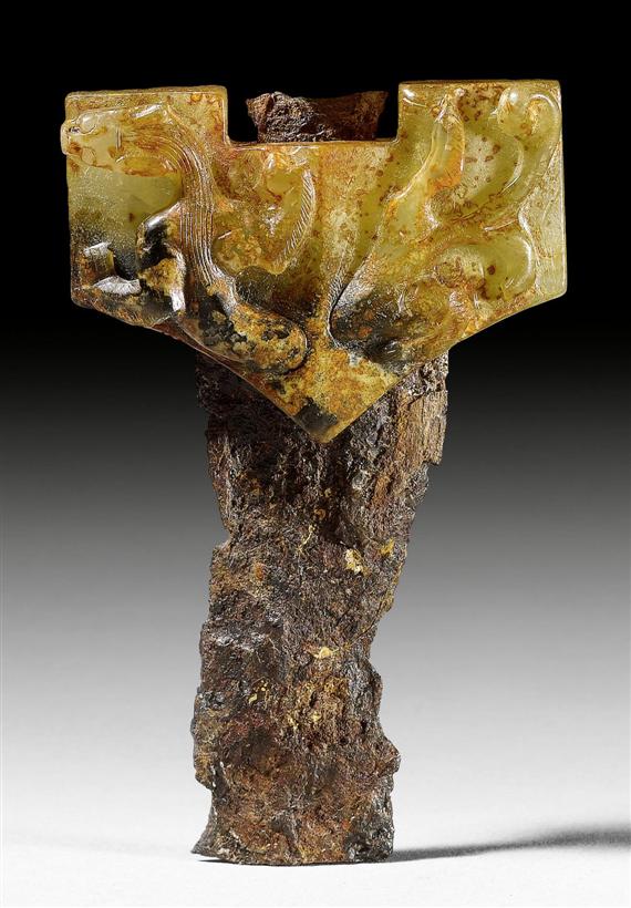 Appraisal: A CARVED JADE SWORD GUARD WITH REMAINS OF THE IRON