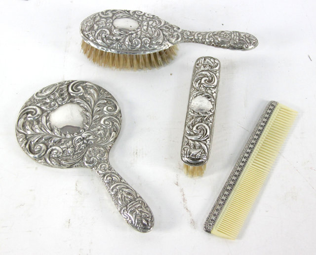 Appraisal: A three-piece silver mounted dressing table set Birmingham embossed foliate