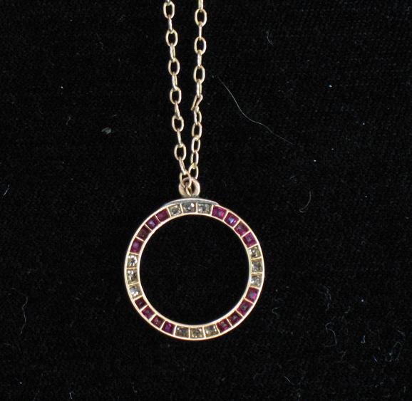 Appraisal: A DIAMOND AND RUBY PENDANT of open circular form the