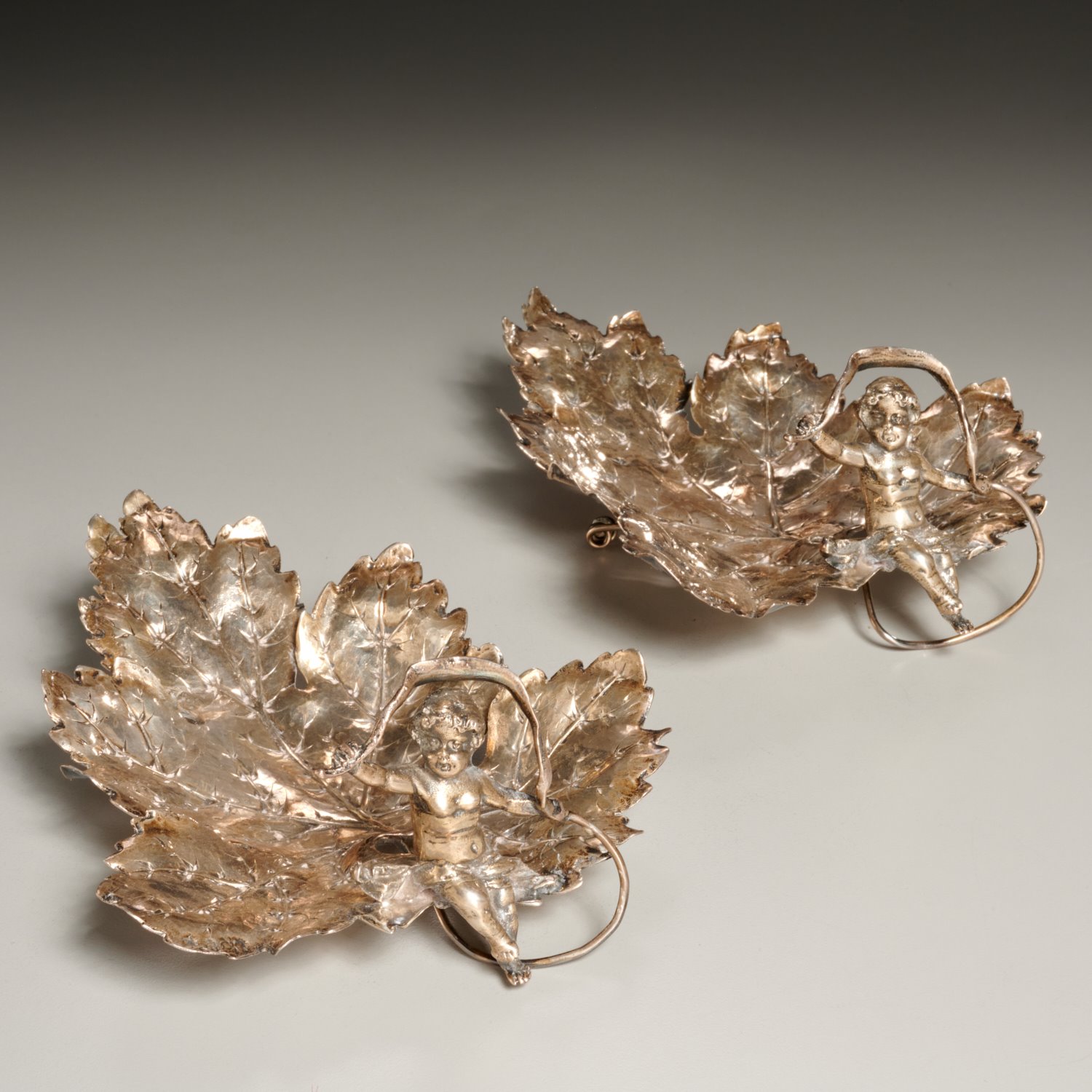 Appraisal: PAIR NERESHEIMER SILVER PUTTO LEAF DISHES Early th c Germany