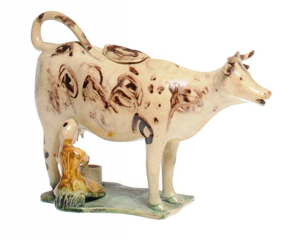 Appraisal: A STAFFORDSHIRE CREAMWARE COW CREAMER the milkmaid seated on the