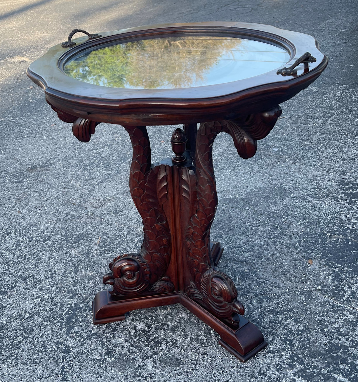 Appraisal: TRI-LEGGED HIGHLY CARVED DOLPHIN TEA TABLE Glass and walnut tea