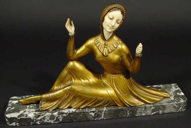 Appraisal: Art Deco spelter and composite reclining figurine in a gilt